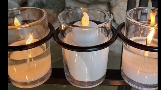 An LED tea light candle in a glass holder. The LED light honors Nick Holonyak, Jr. and his invention of the LED light.